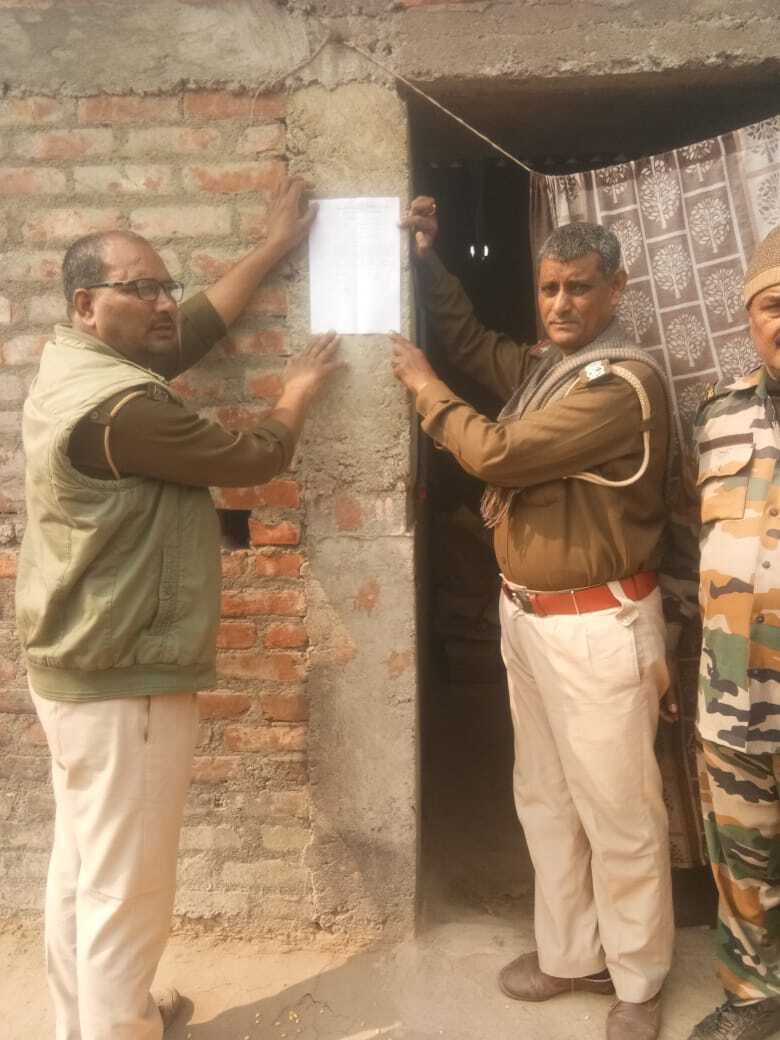 फरार आरोपी के घर पुलिस ने चिपकाया इश्तेहार