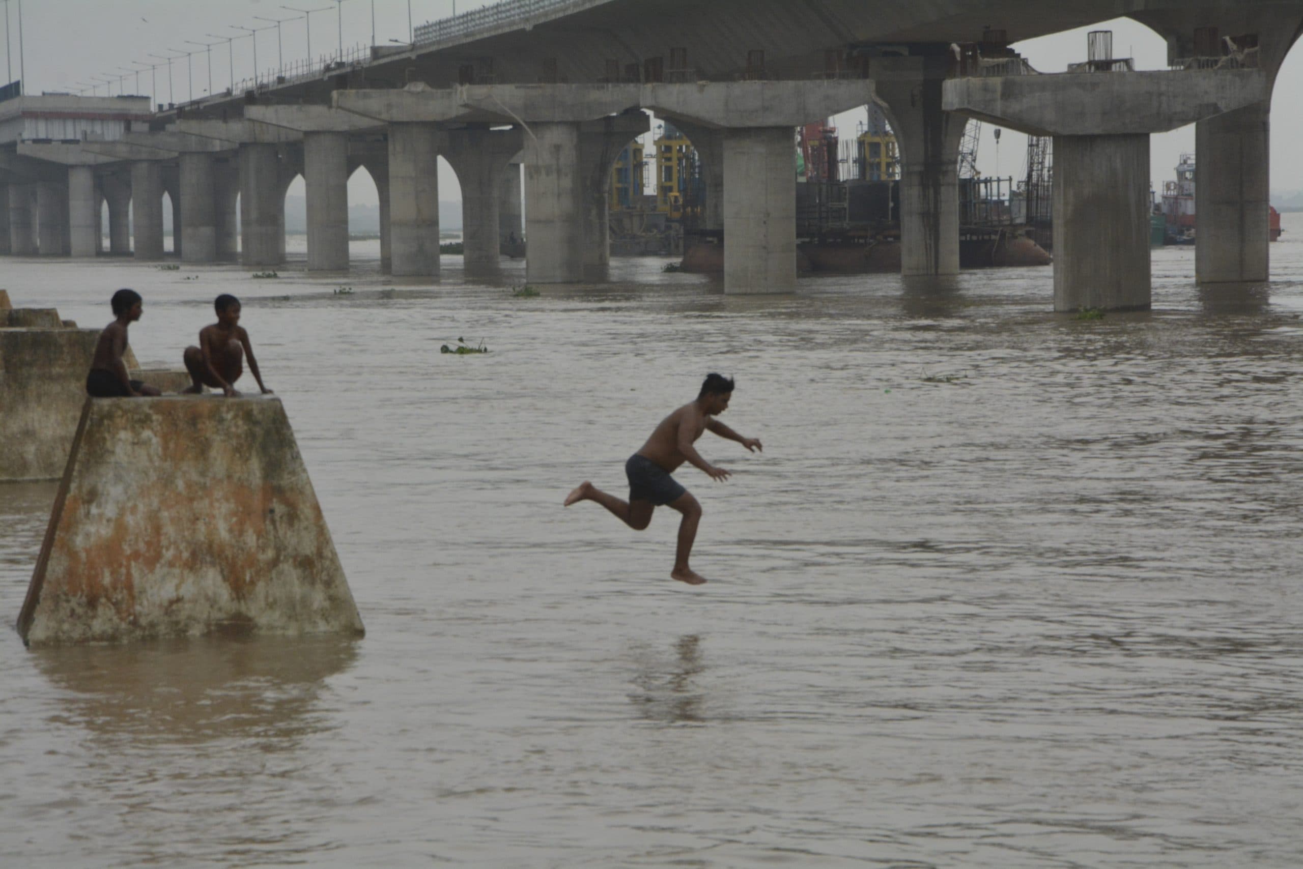 राजधानी पटना में गंगा उफान पर, जान जोखिम में डालकर डुबकी लगा रहे बच्चे, देखें तस्वीरें