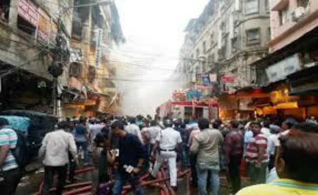 बागड़ी मार्केट की आग बुझी, पर निकल रहा धुआं, मार्केट से लगातार निकल रहे धुएं के कारण आसपास छाया अंधेरा