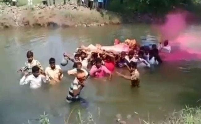 Shocking: कमर भर पानी में डूबकर यहां मुर्दे को श्मशान पहुंचाते हैं लोग
