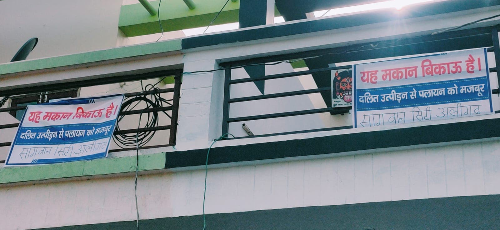 अलीगढ़ की सांगवान सिटी में फ्लैट्स पर लगे 'उत्पीड़न से पलायन को मजबूर दलित, मकान बिकाऊ है...' के फ्लैक्स