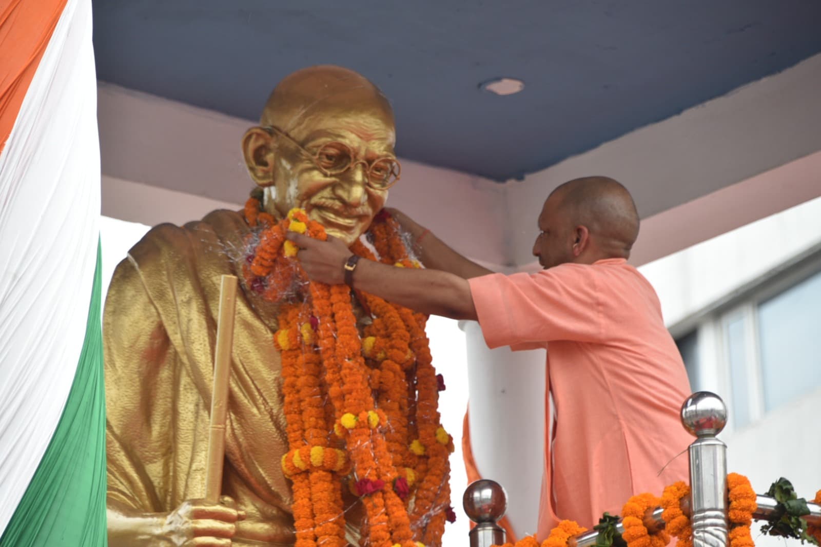 सीएम योगी ने महात्मा गांधी और लाल बहादुर शास्त्री की प्रतिमाओं पर किया माल्यार्पण, चरखा भी चलाया