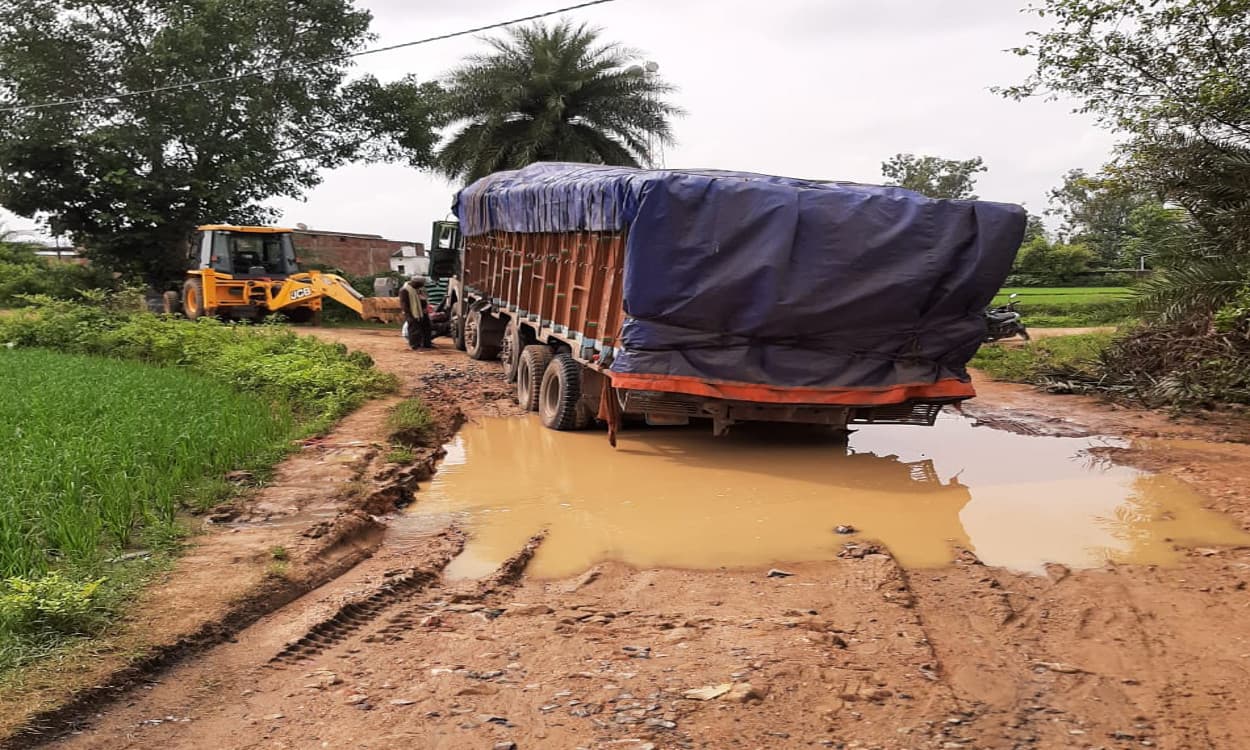 कीचड़ भरे गड्ढे में तब्दील हो गयी बानपुर की सड़क, जेसीबी से टोचन के बाद पार हाेते हैं ट्रक