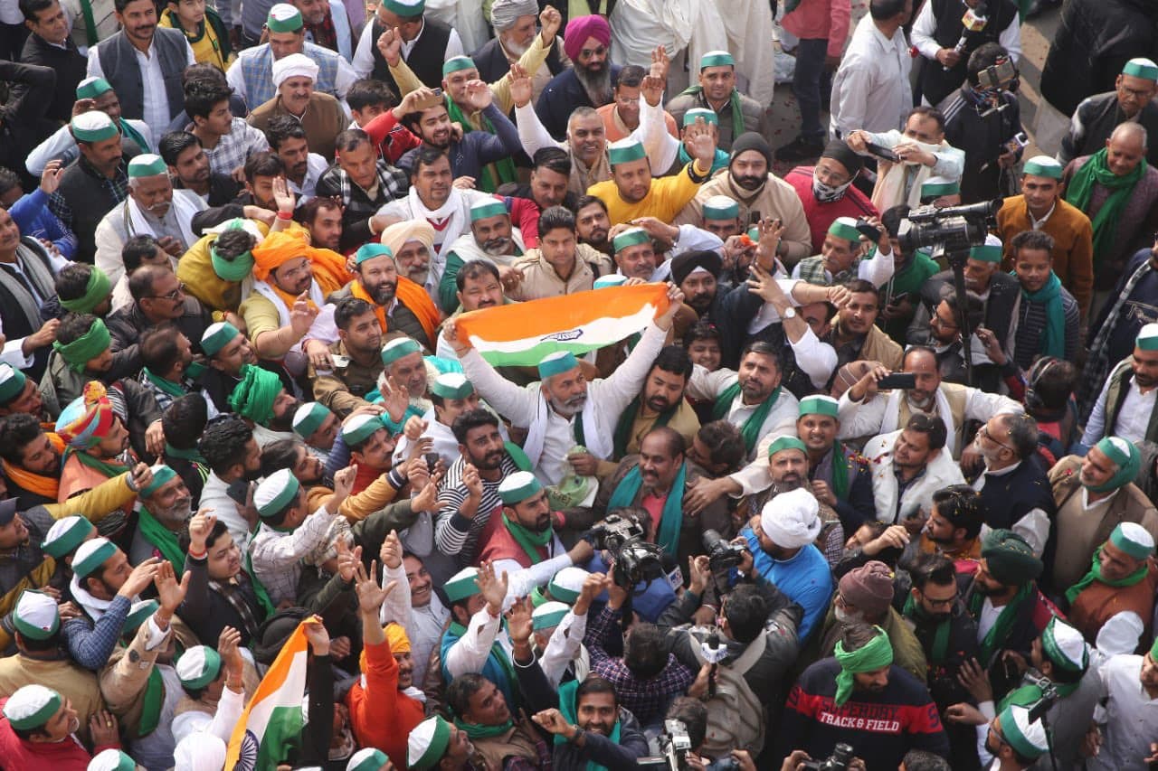 Kisan Andolan: किसान नेता राकेश टिकैत आंदोलन खत्म कर लौटे घर, फूलों की बारिश और गाजे-बाजे की गूंज से स्वागत