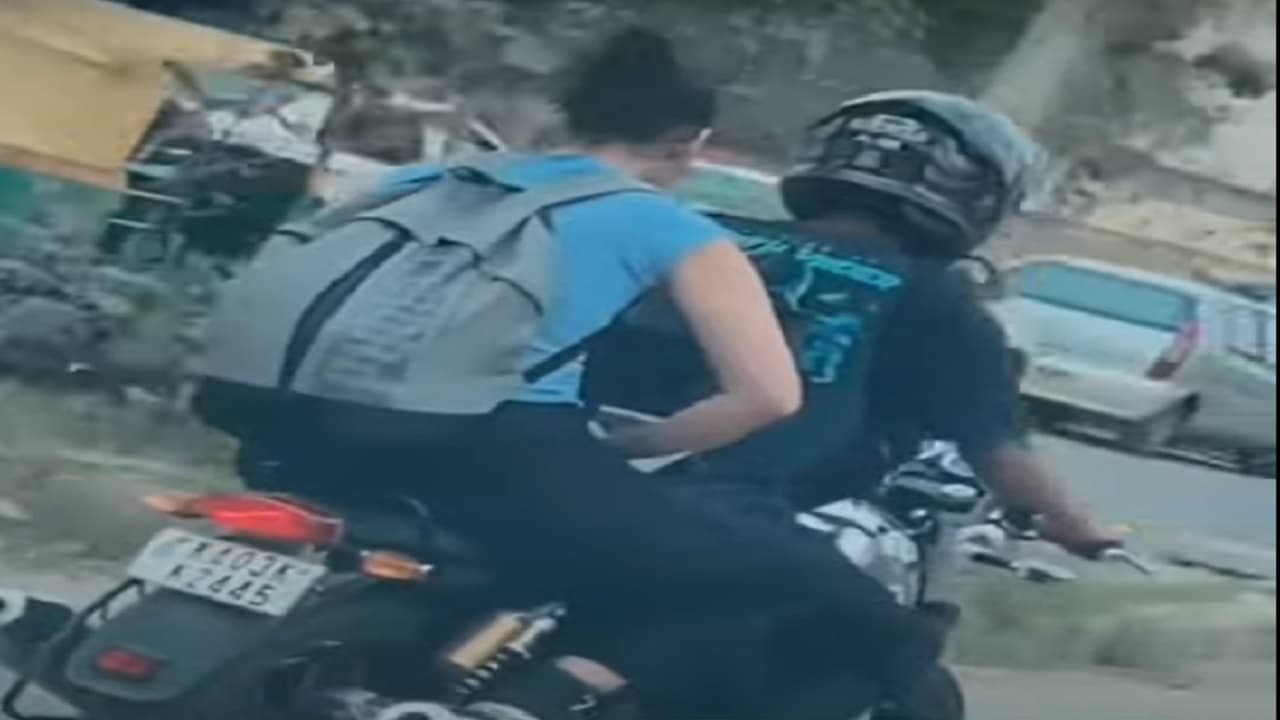 बेंगलुरु में रॉयल एनफील्ड पर लैपटॉप से काम करती दिखी महिला, देखें PHOTO