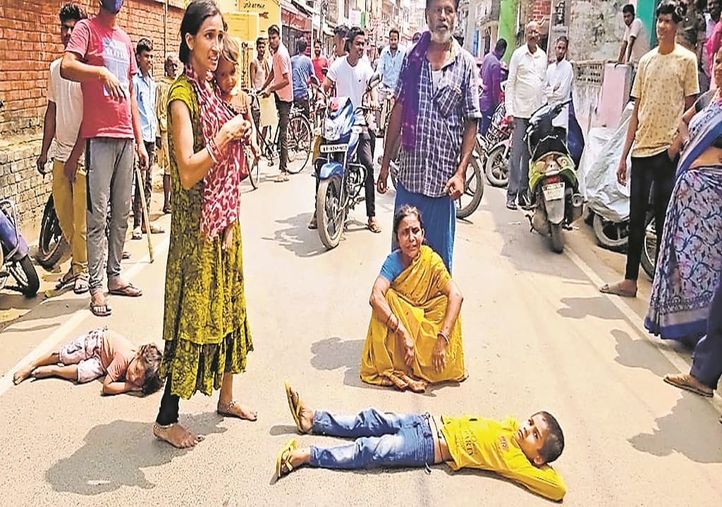 Munger News: शराब कारोबारी बेटे व भैंसुर  से प्रताड़ित महिला ने बच्चों को बीच सड़क पर लिटाया, लगा जाम