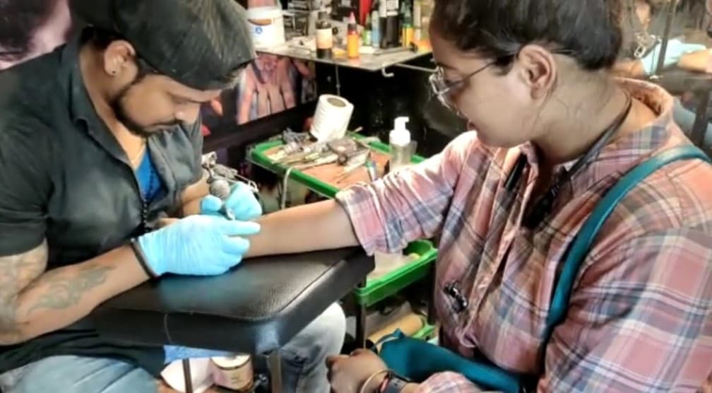 वाराणसी पहुंच रहे भोले बाबा के युवा भक्‍तों में टैटू का दिख रहा क्रेज, बनवा रहे शिव आकृति, नंदी और डमरू