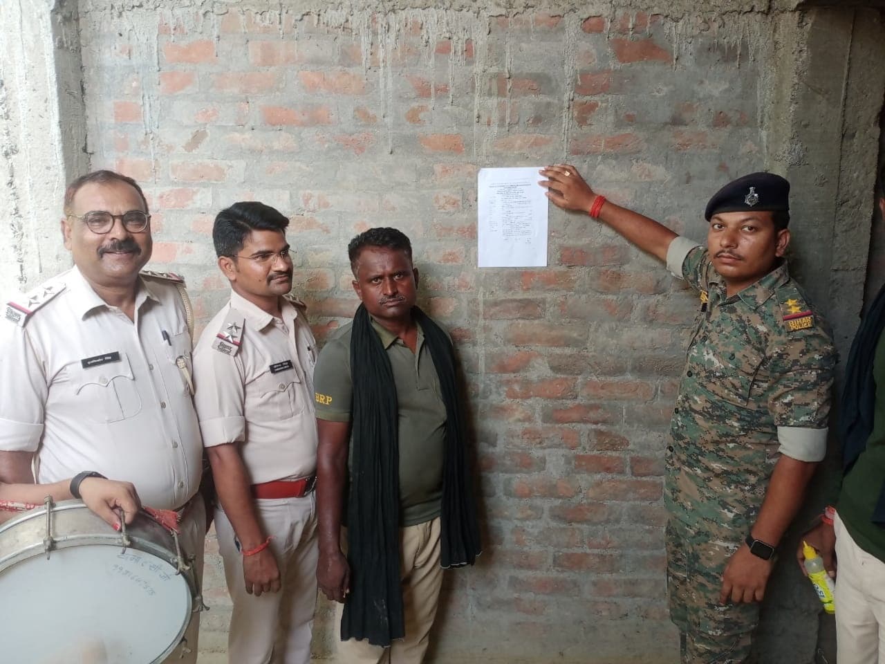 फरार वारंटी के घर पर पुलिस ने चिपकाया इश्तेहार