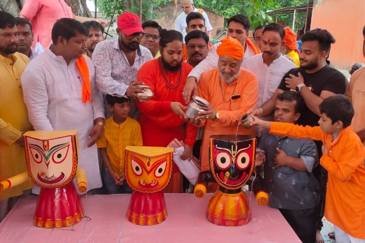 भगवान जगन्नाथ, बलभद्र व सुभद्रा को स्नान कराते पुजारी