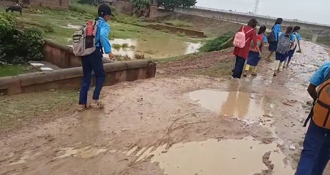 कीचड़ से सनी सड़क से होकर विद्यालय जाते हैं छात्र
