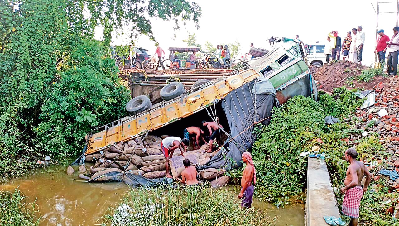 रघुनाथपुर में चावल लदा ट्रक पुल से नीचे गिर कर पलटा, दो घायल
