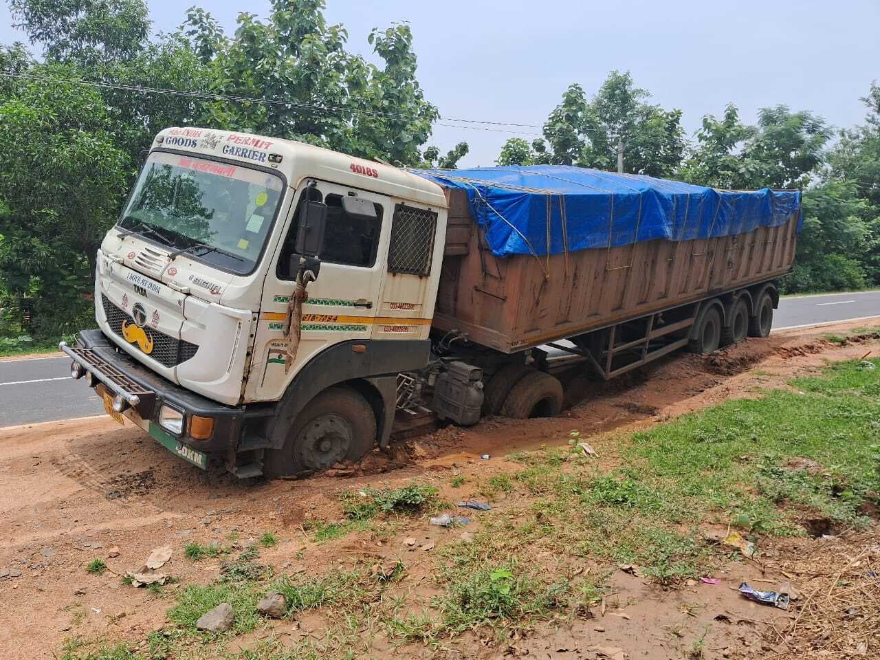 सड़क किनारे गीली मिट्टी में धंसा ट्रक