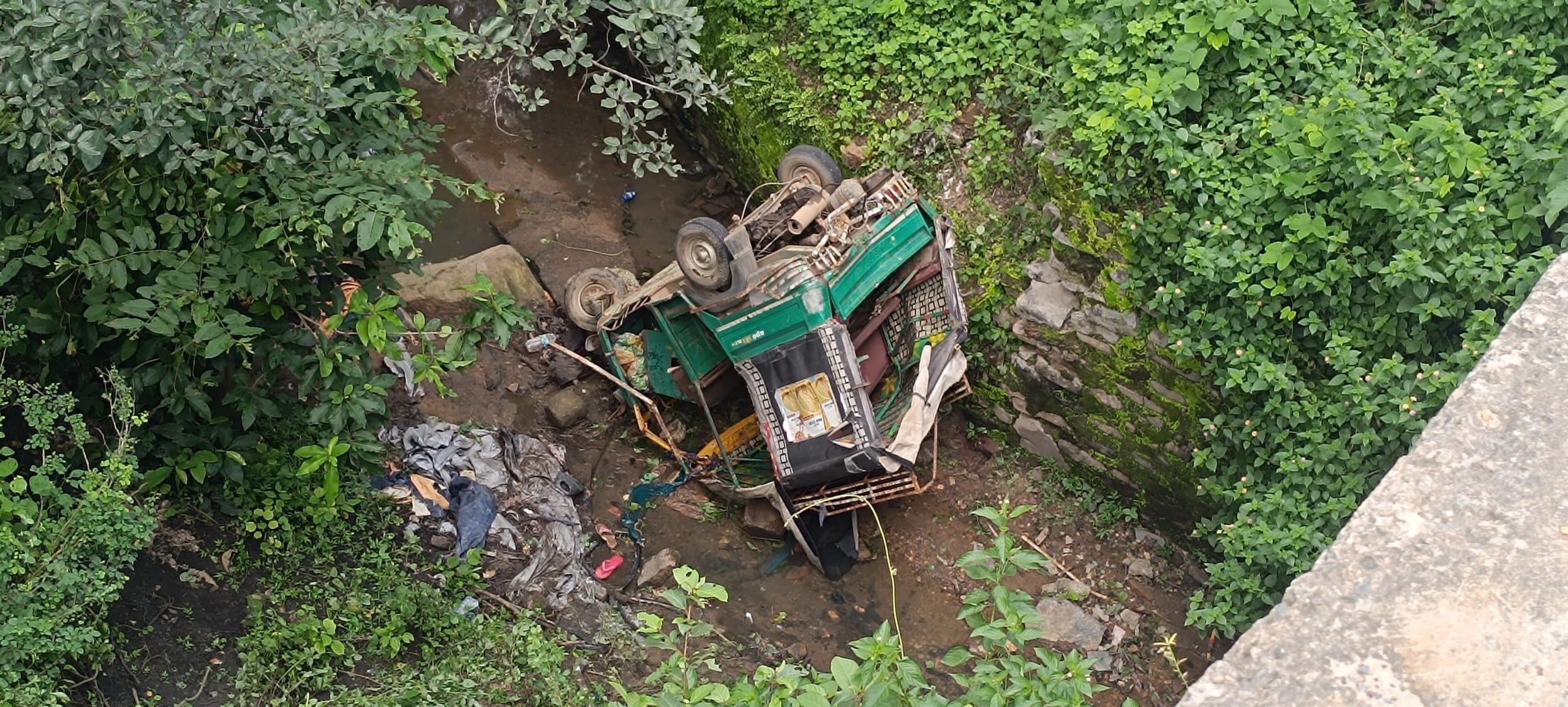 कंटेनर की टक्कर से 20 फीट नीचे खाई में गिरा ऑटो, बच्ची की मौत, 14 घायल