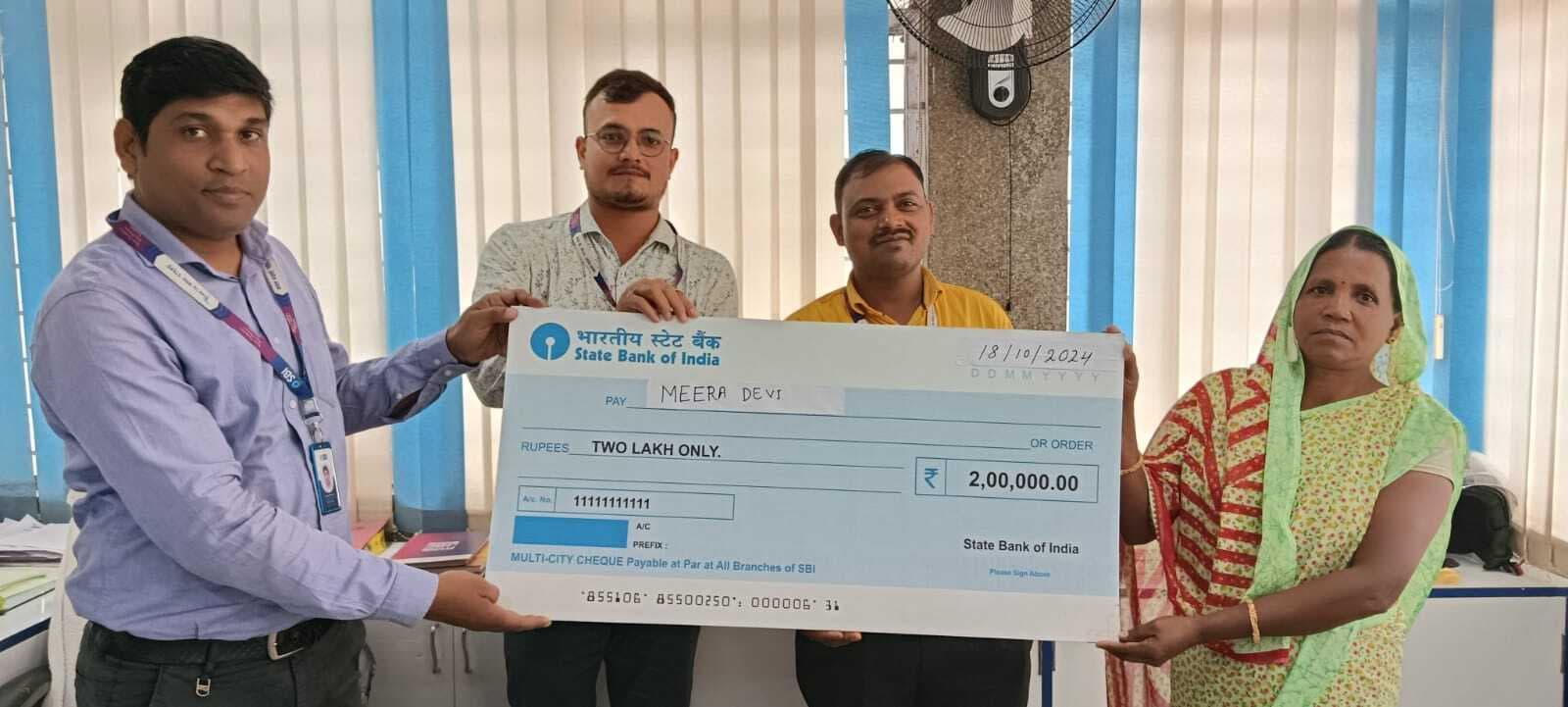 मृतक की विधवा पत्नी को दिया गया दो लाख रूपये का चेक