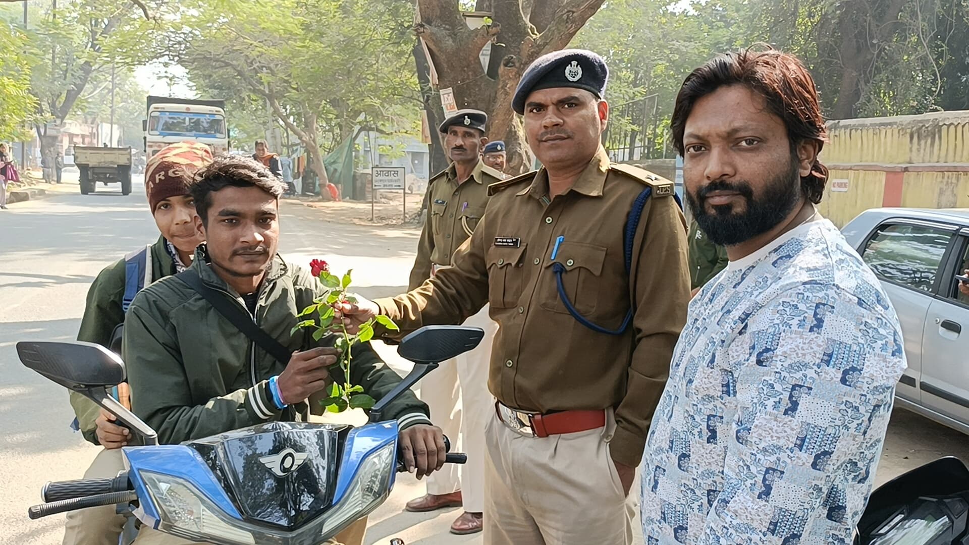 लोगों को गुलाब फूल देकर हेलमेट पहनने के लिए किया जागरूक