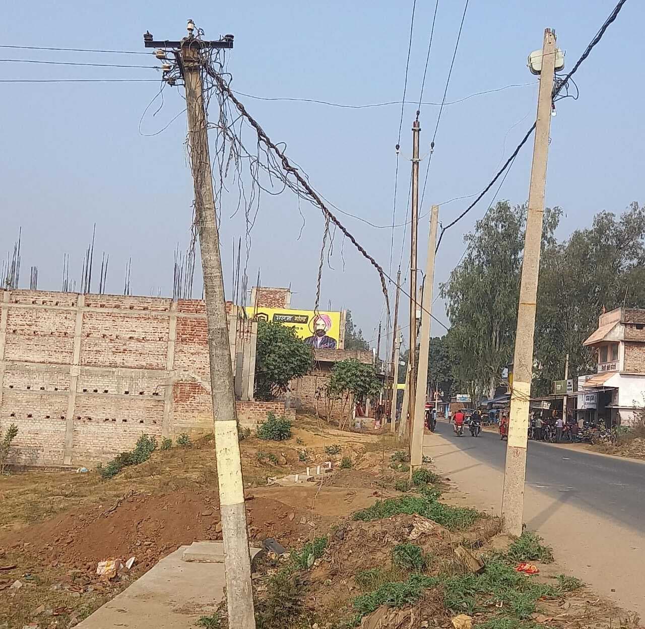 सड़क किनारे झुका बीजली का पोल