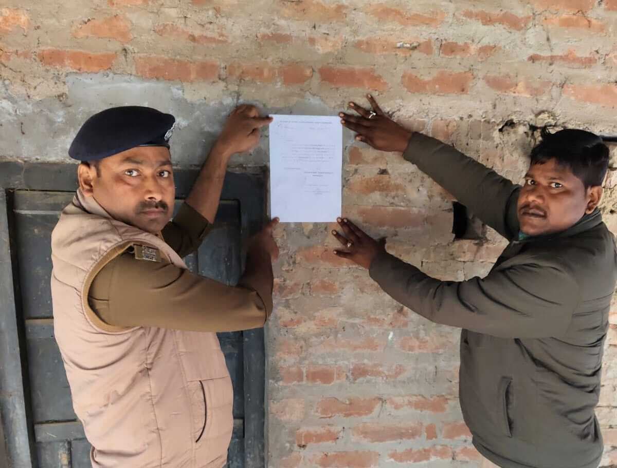 हत्या के आरोपित के घर पुलिस ने चिपकाया इश्तेहार