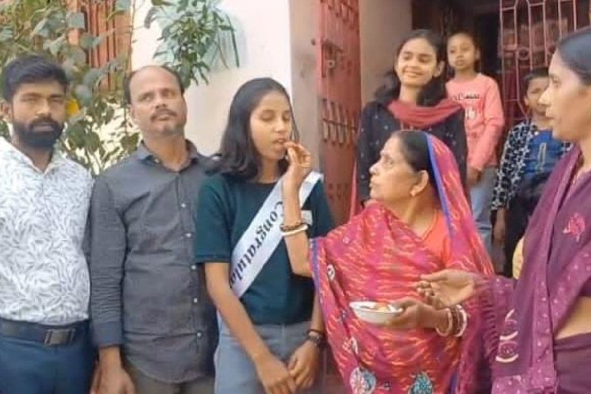 सेकेंड टॉपर प्रिया को मिठाई खिलाते परिजन