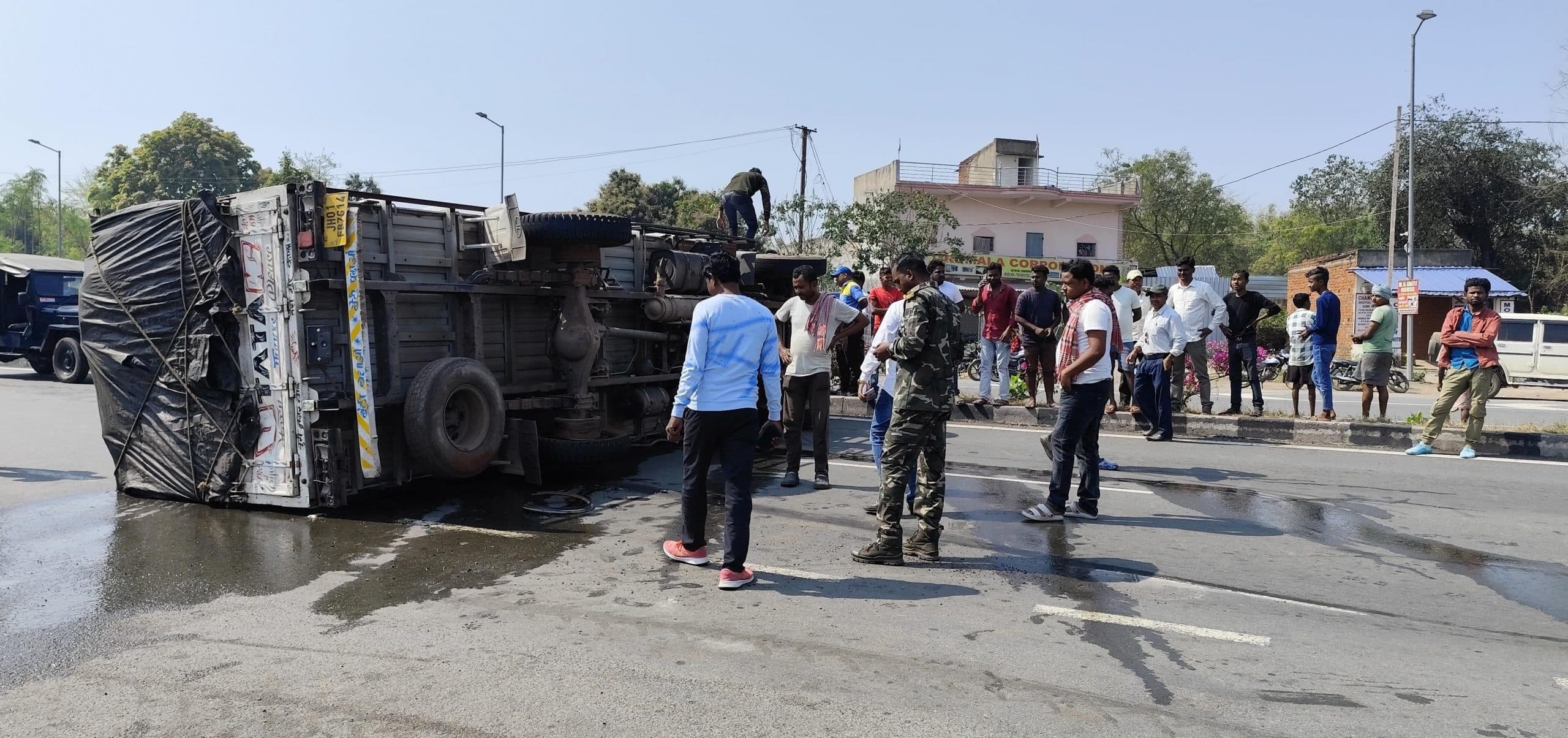 East Singhbhum News : एनएच पर टायर फटने से शराब लदा ट्रक पलटा, बोतलें टूटने से बही शराब, तीन घंटे जाम