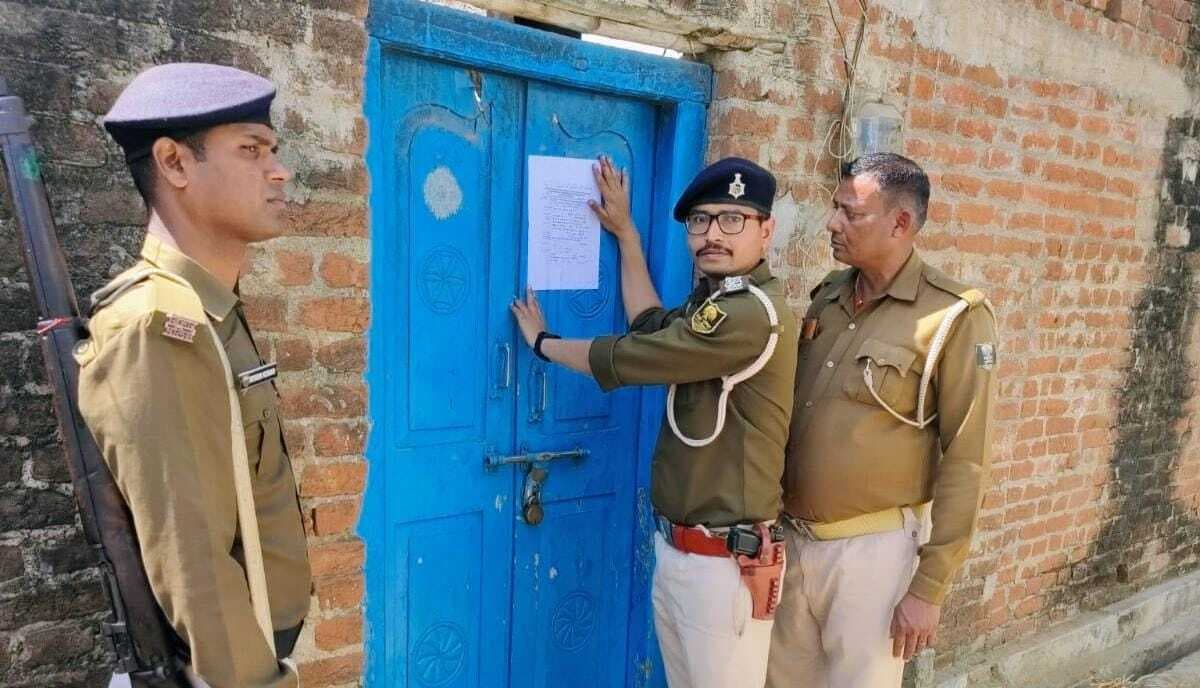 दो फरार आरोपी के घर पुलिस ने चिपकाया इश्तेहार