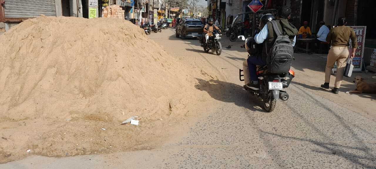 Madhubani News : शहर की मुख्य सड़कों पर भवन निर्माण सामग्री रख लोग बना रहे मकान