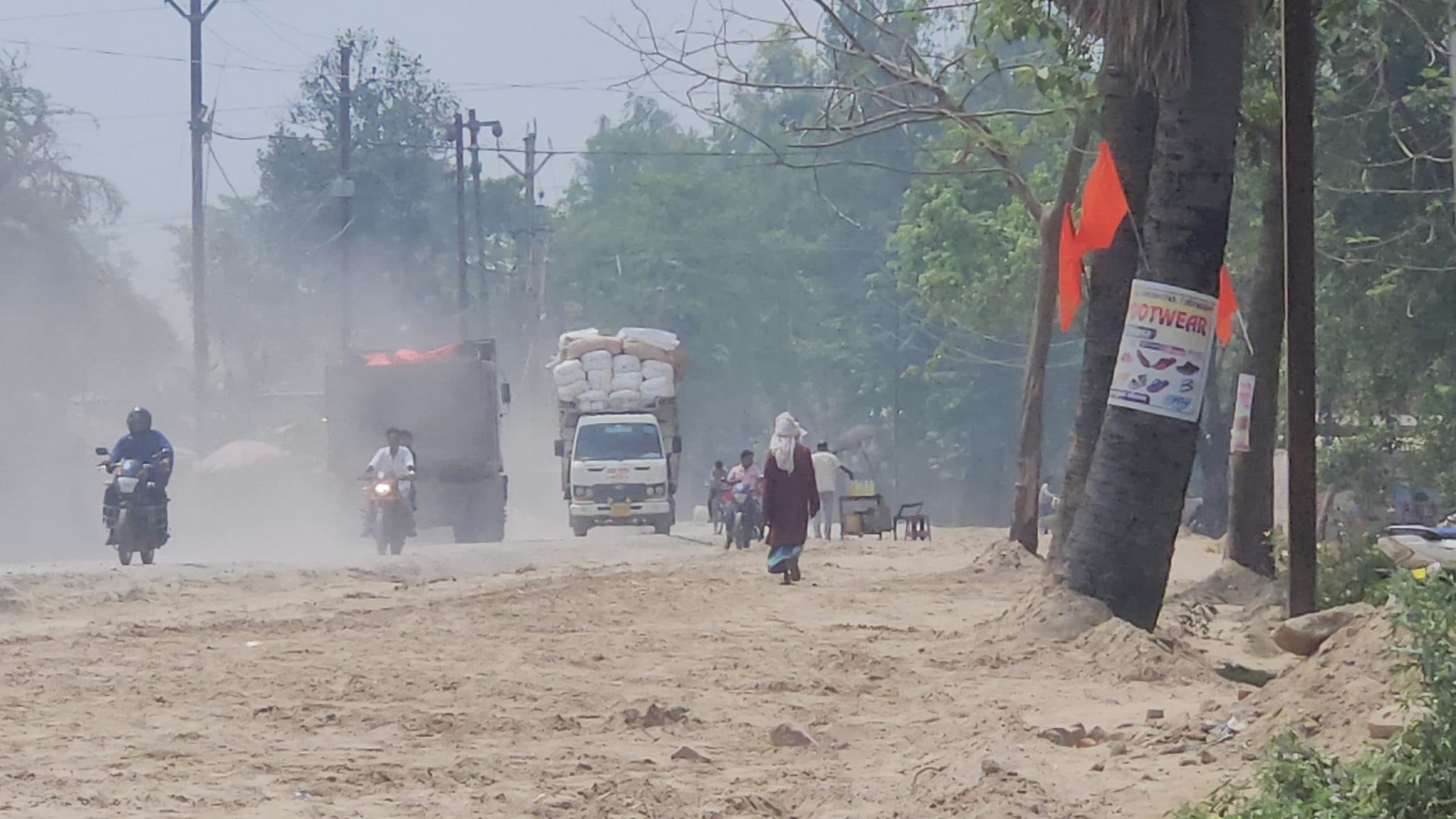 सड़क निर्माण के दौरान पानी का छिड़काव नहीं होने से उड़ रही धूल से लोग परेशान