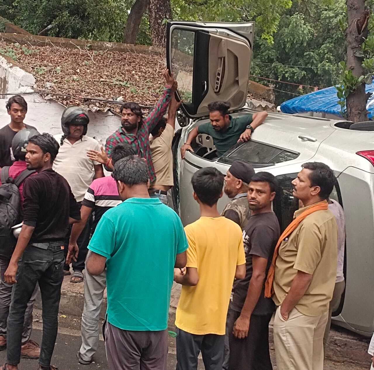 Dhanbad News : पूजा टॉकीज के पास फुटपाथ पर चढ़कर पलटी कार, घड़ा विक्रेता जख्मी