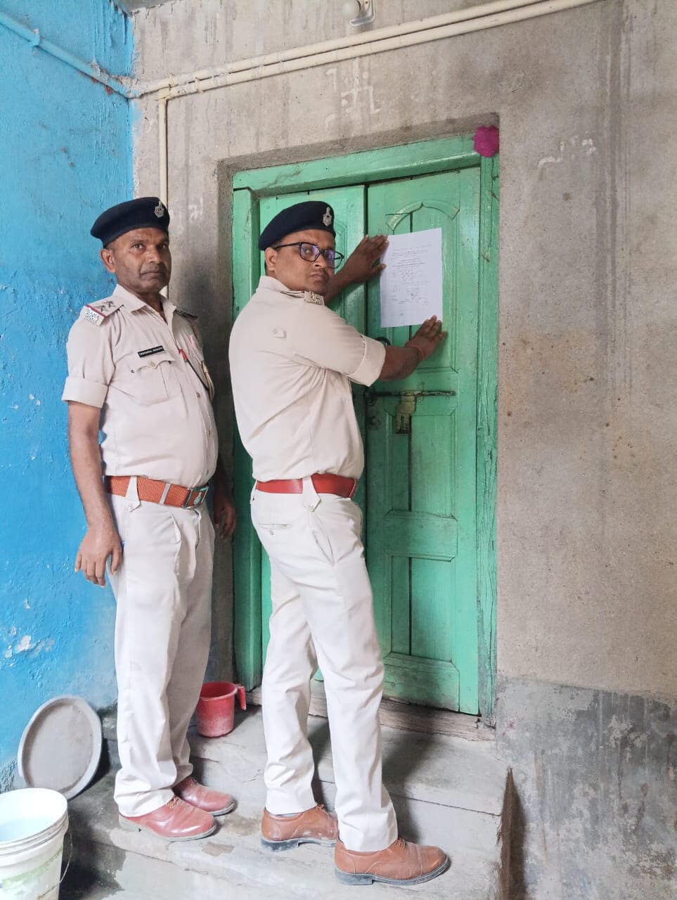 लाखों रुपये ठगी के मामले में अभियुक्त के घर पुलिस ने चिपकाया इश्तेहार