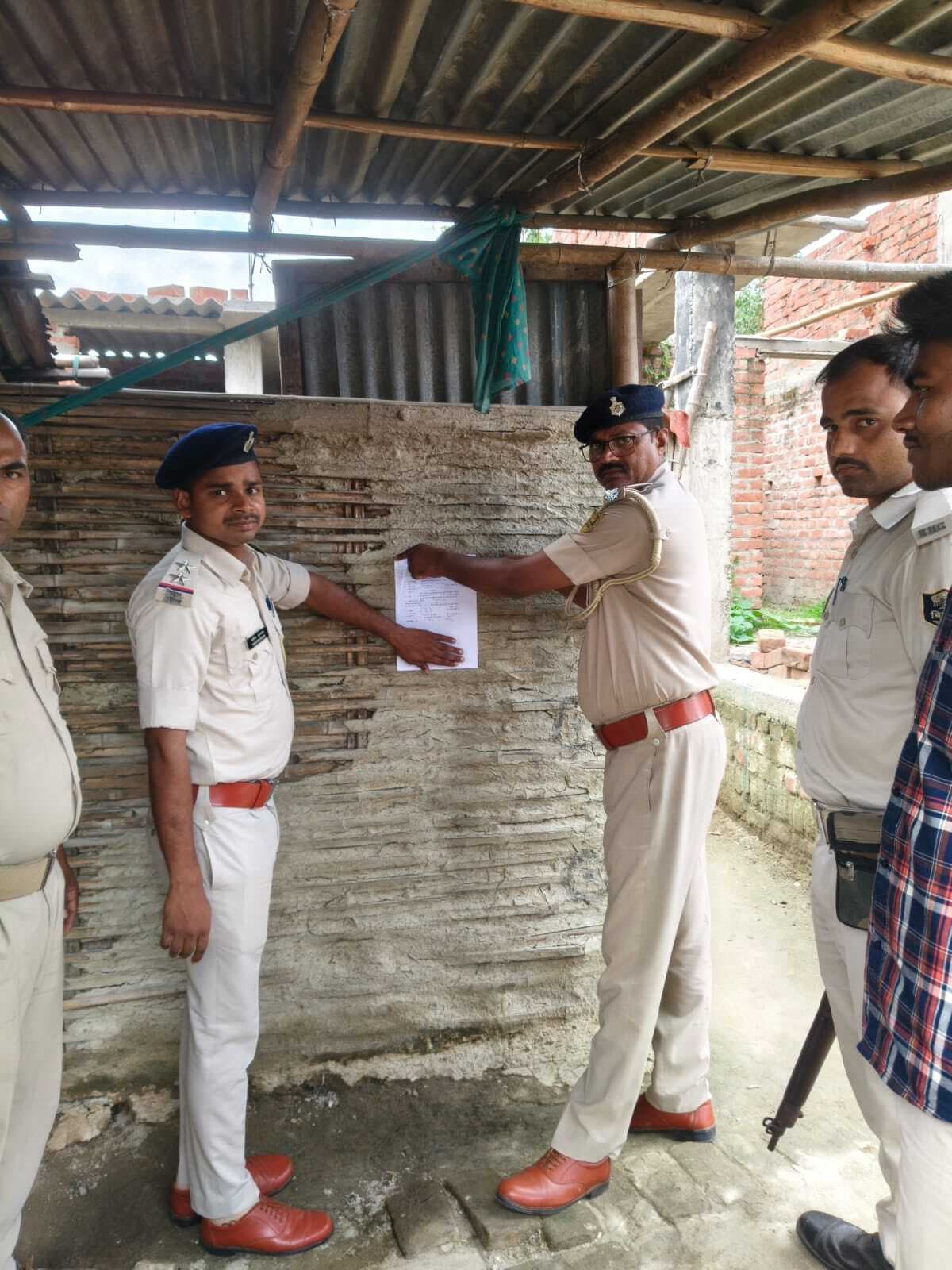 शराब मामले में फरार आरोपित के घर चिपकाया इश्तेहार