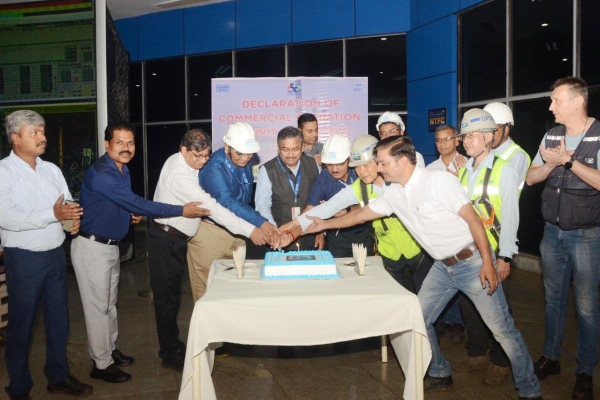 बिजली उत्पादन शुरू होने के बाद केक काटकर खुशी मनाते अधिकारी