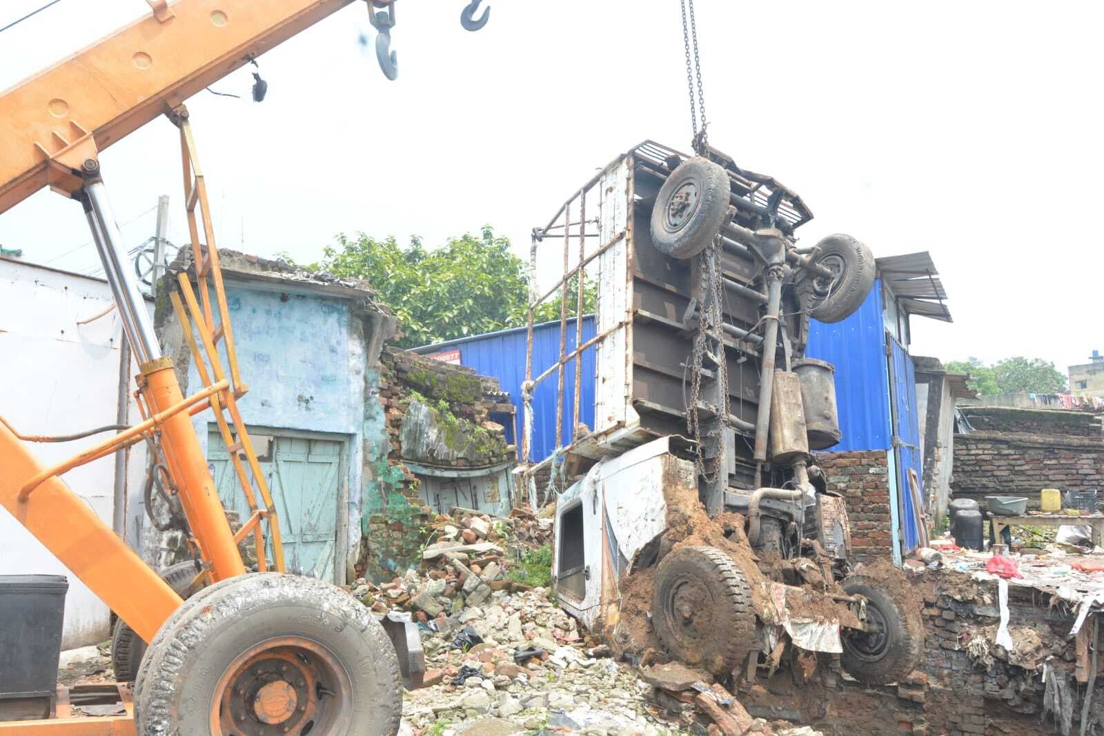 Dhanbad News : काफी मशक्कत के बाद जमीन के अंदर से निकाला गया वाहन, भराई के दौरान दुकान का छज्जा गिरा