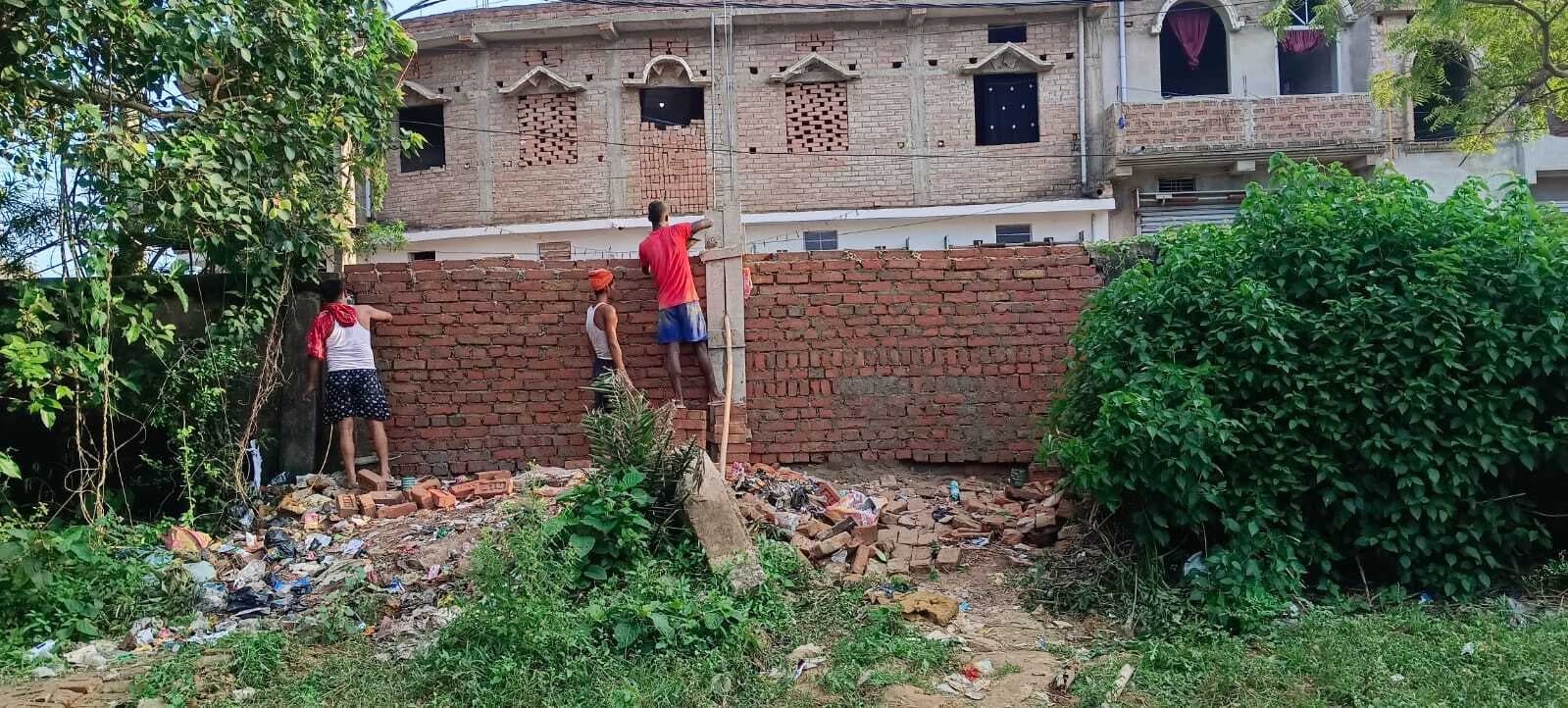 भू-माफिया द्वारा तोड़ी गयी दीवार का पुर्ननिर्माण