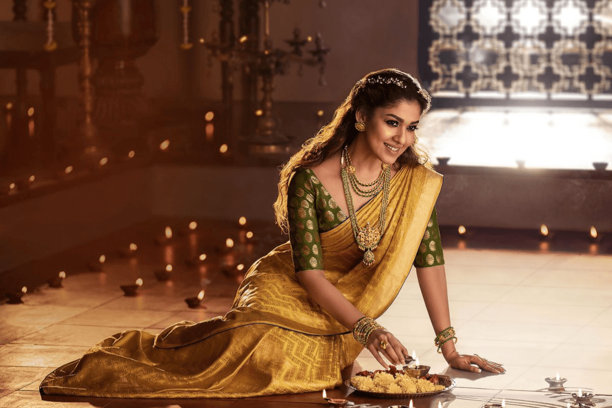 Woman holding flower in ethnic outfit for Teej photography idea.