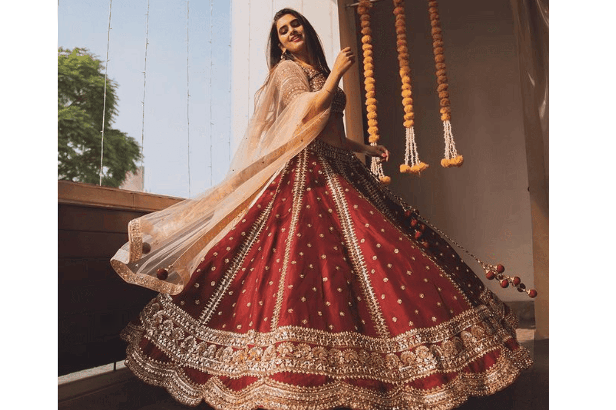 Gorgeous Indian woman twirling in lehenga for Teej festival photography pose.