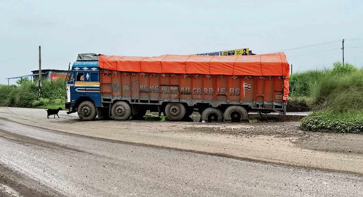 Seraikela Kharsawan News : राजनगर-सरायकेला मार्ग के गड्ढे में फंसा ट्रेलर, भारी वाहनों का आवागमन हुआ ठप