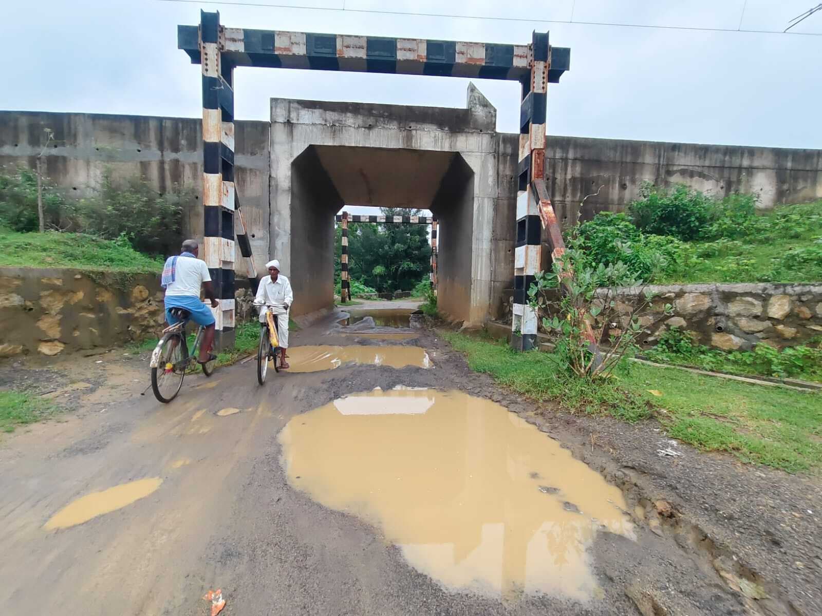 रेलवे पुल के नीचे सड़क पर गड्ढों से राहगीर परेशान