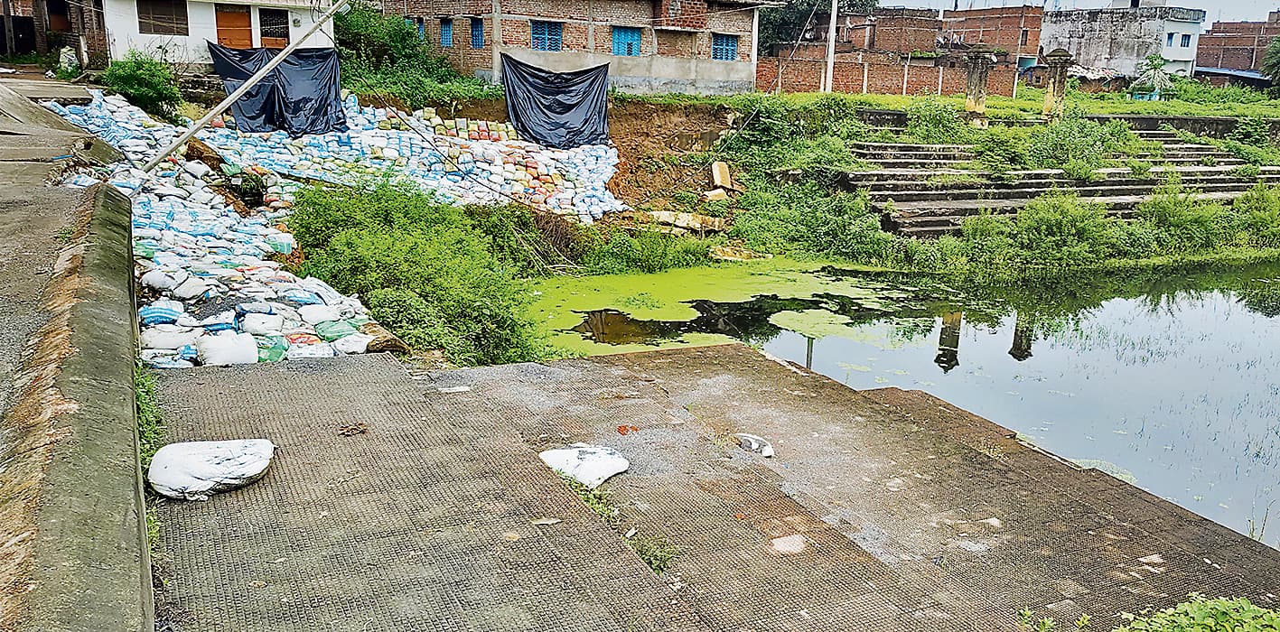 Gaya News : बारिश से धंसी दीवार, मिट रहा शेरघाटी का ऐतिहासिक तालाब