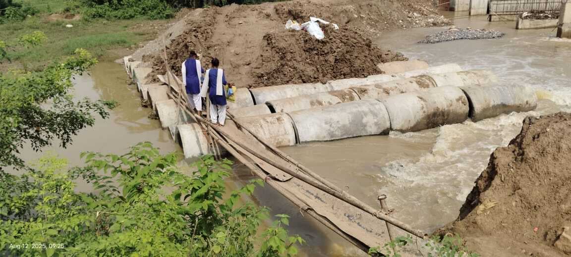 लोहे की छड़ों व पाइपों के सहारे क्षतिग्रस्त डायवर्सन पार करती स्कूली छात्राएं