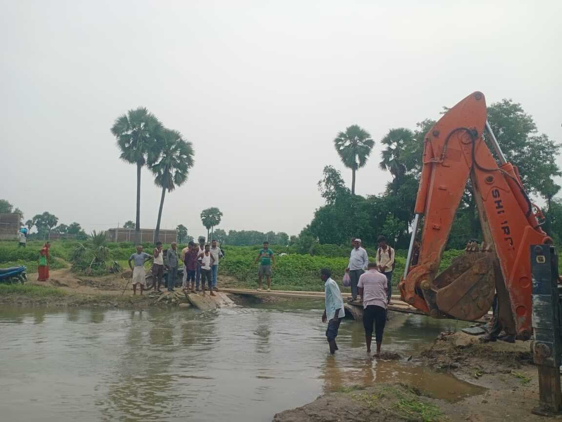 गोकुला नदी पर ग्रामीणों ने बिजली का खंभा रखकर बनाया अस्थायी रास्ता