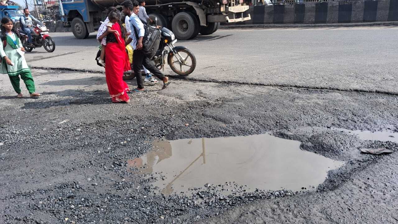 Dhanbad News : सड़क पर बने गड्ढों से हो रहे हादसे, पानी के बहाव के कारण कई स्थानों पर टूट गयी है सर्विस लेन