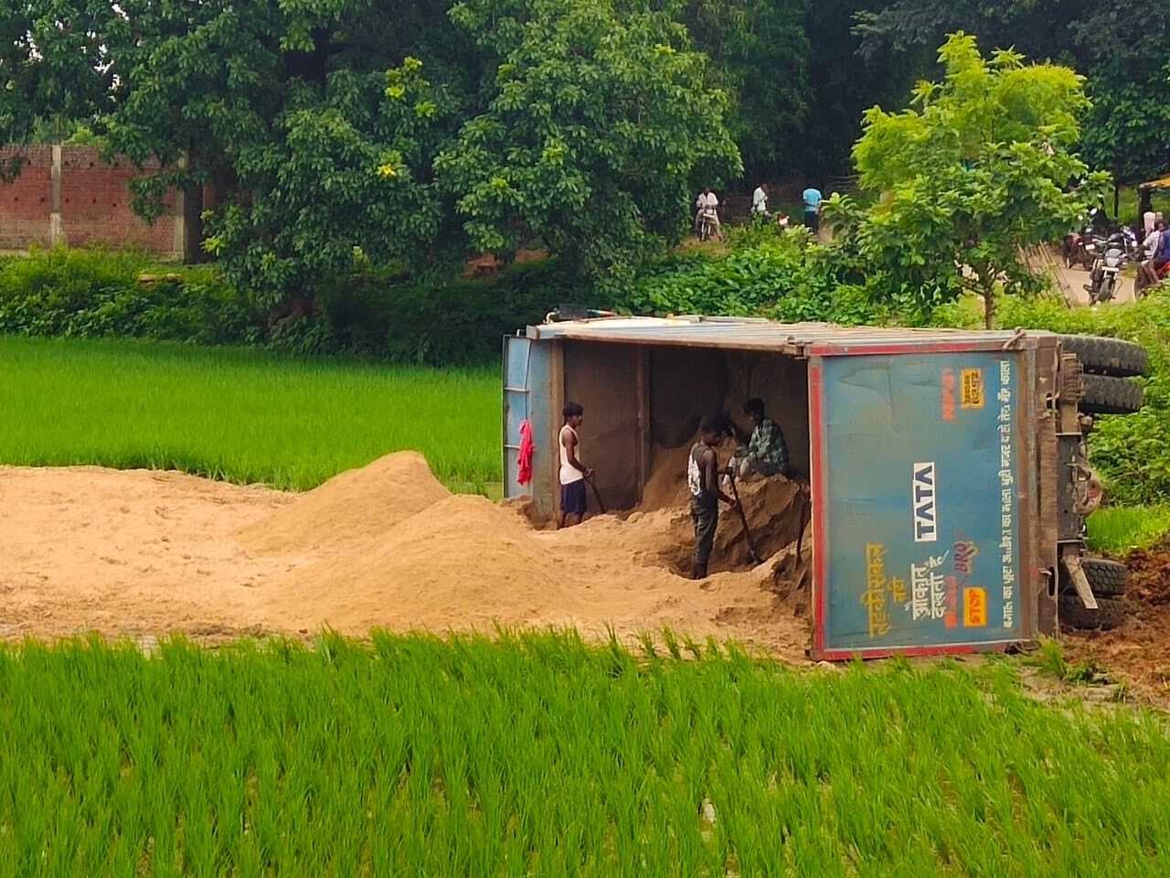 East Singhbhum News : बालू लदा हाइवा खेत में पलटा, धान की फसल बर्बाद