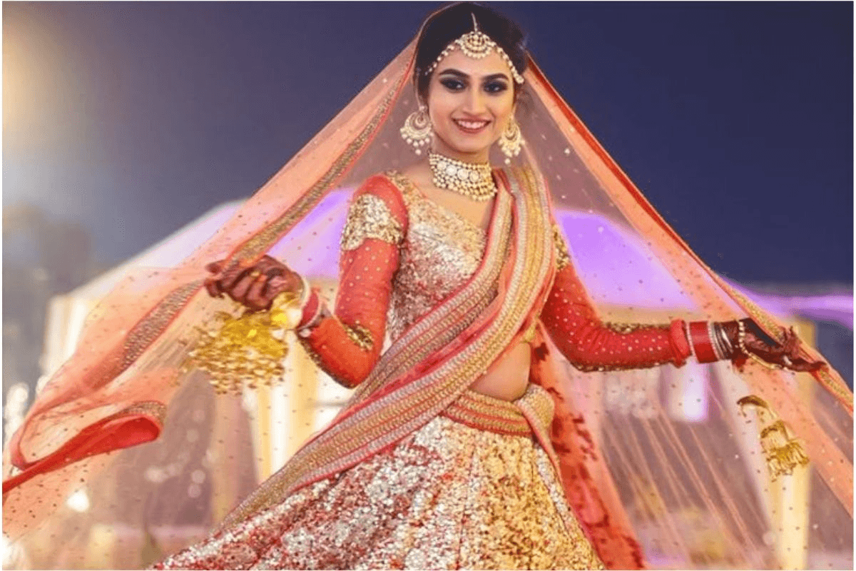 Elegant Teej photography pose of woman turning back in lehenga.