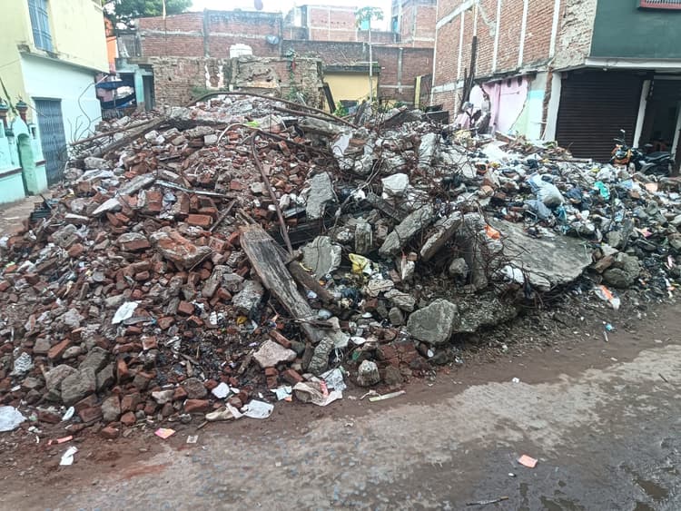 सड़क के बीच में उभरे गड्ढे बने जानलेवा, पोस्टऑफिस के पास मलबे का ढे़र