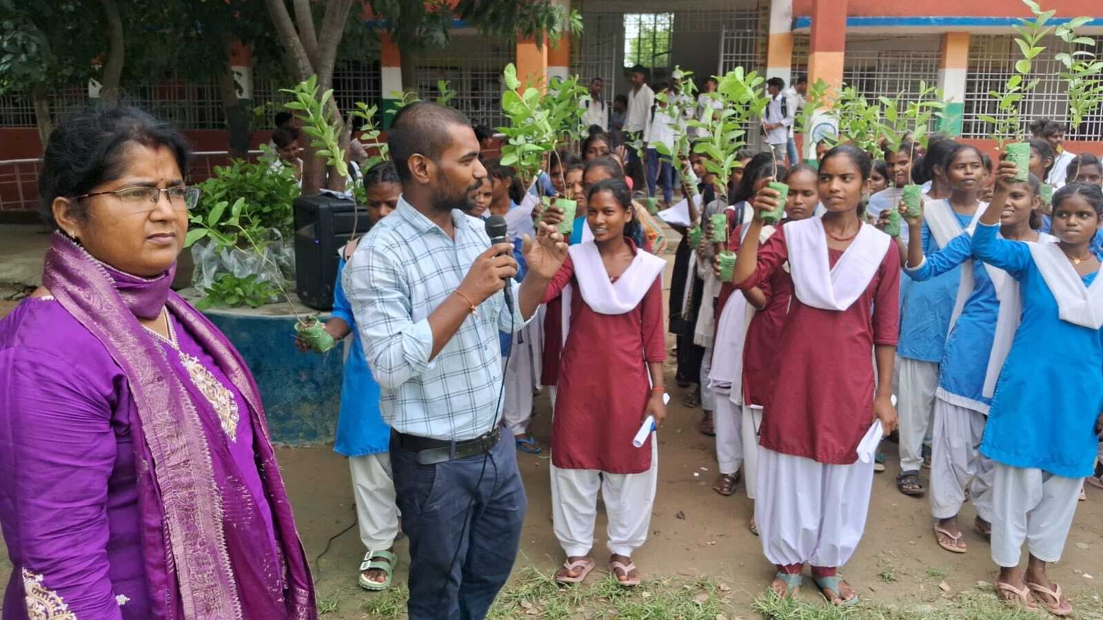 स्कूली बच्चों को दिये गये अमरूद के पौधे