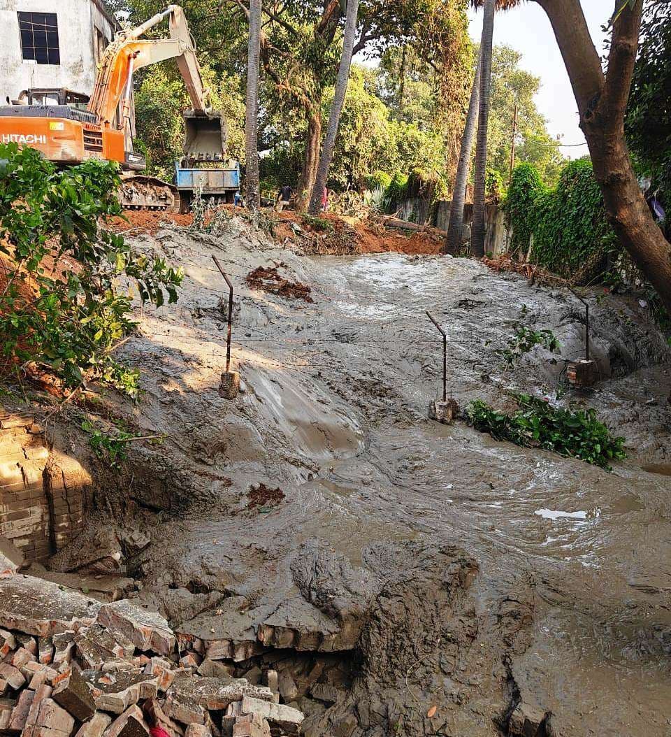 कस्तूरबा वाटर हिल की सफाई से निकले कीचड़ के बहाव ने तोड़ी दीवार