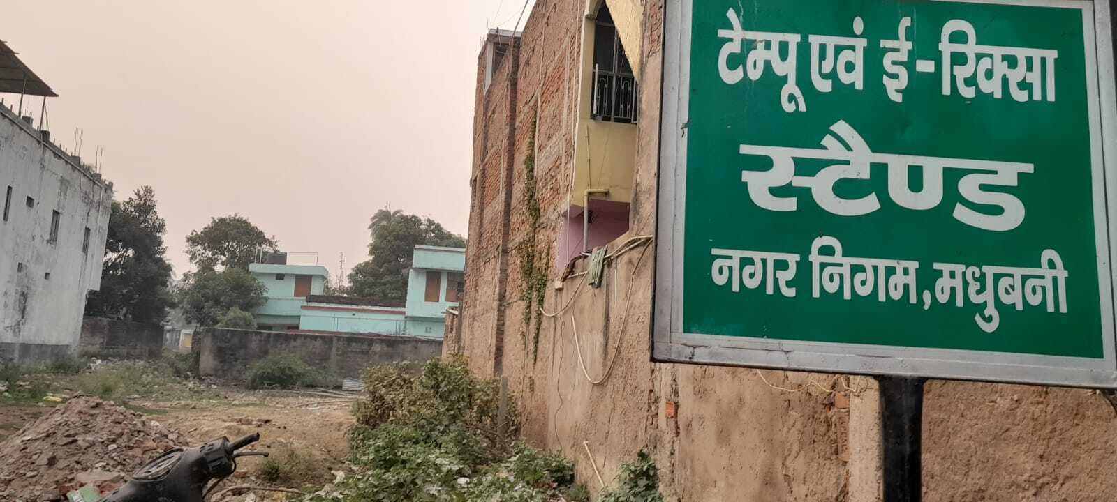 Madhubani News : एक वर्ष पूर्व स्टेशन के समीप टेंपो व ई रिक्शा स्टैंड निर्माण का लगा था बोर्ड