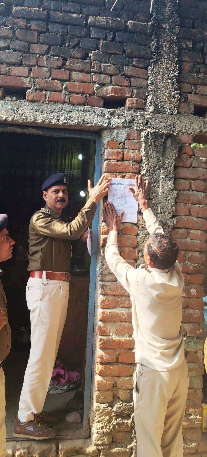 फरार अभियुक्त के घर पुलिस ने चिपकाया इश्तेहार, कुर्की की चेतावनी