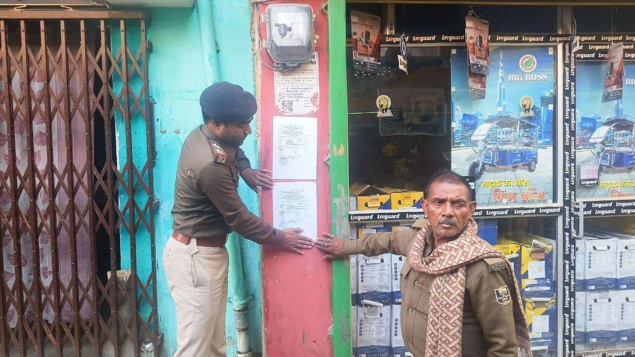 मारपीट मामले के फरार आरोपित के घर पुलिस ने चिपकाया इश्तेहार