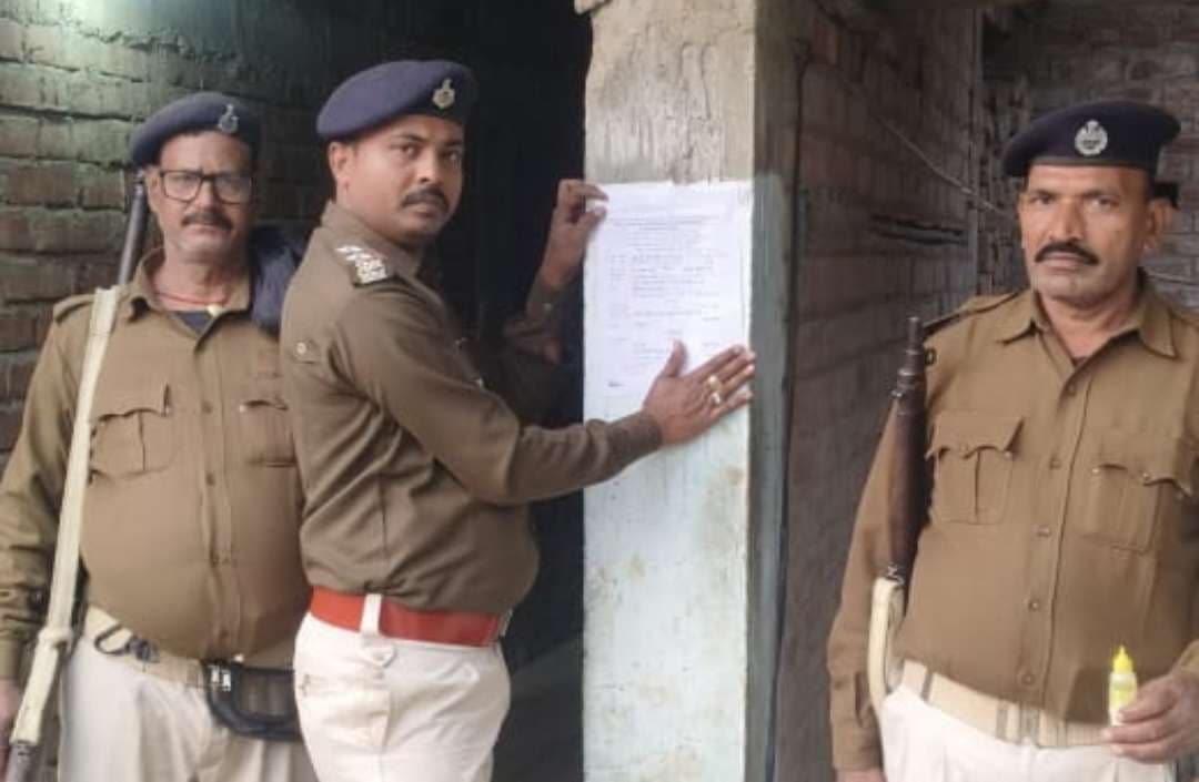 फरार तीन अभियुक्तों के घर पर पुलिस ने चिपकाया इश्तेहार