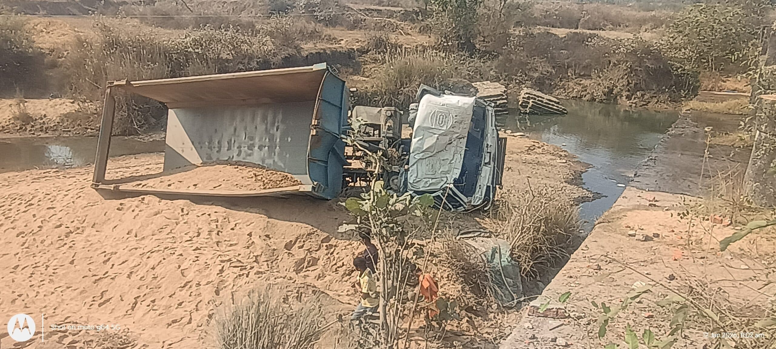 अवैध बालू हाईवा पुल के नीचे नदी में गिरी, बाल-बाल बचे चालक